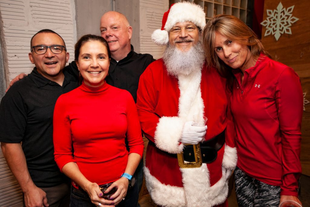 Santa posing with guests at Circa Real Estate's Christmas party
